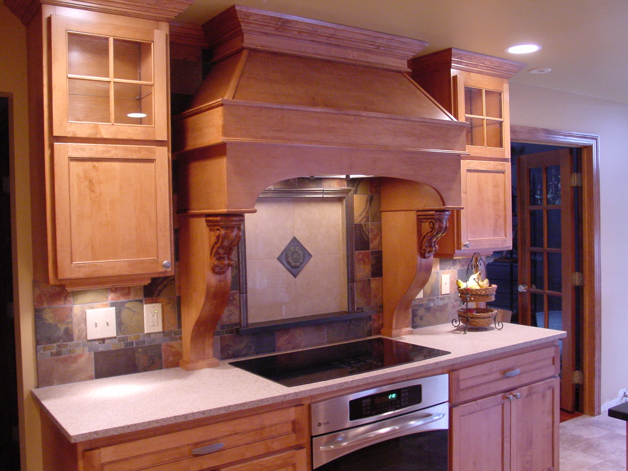 Custom wood hood in Maple Wood stain. Custom double doors with glass mullions and plenty of roll-out shelves. This great kitchen is located in Upper Bucks, Yardley, Lower Makefield area. All new wood kitchen cabinets.