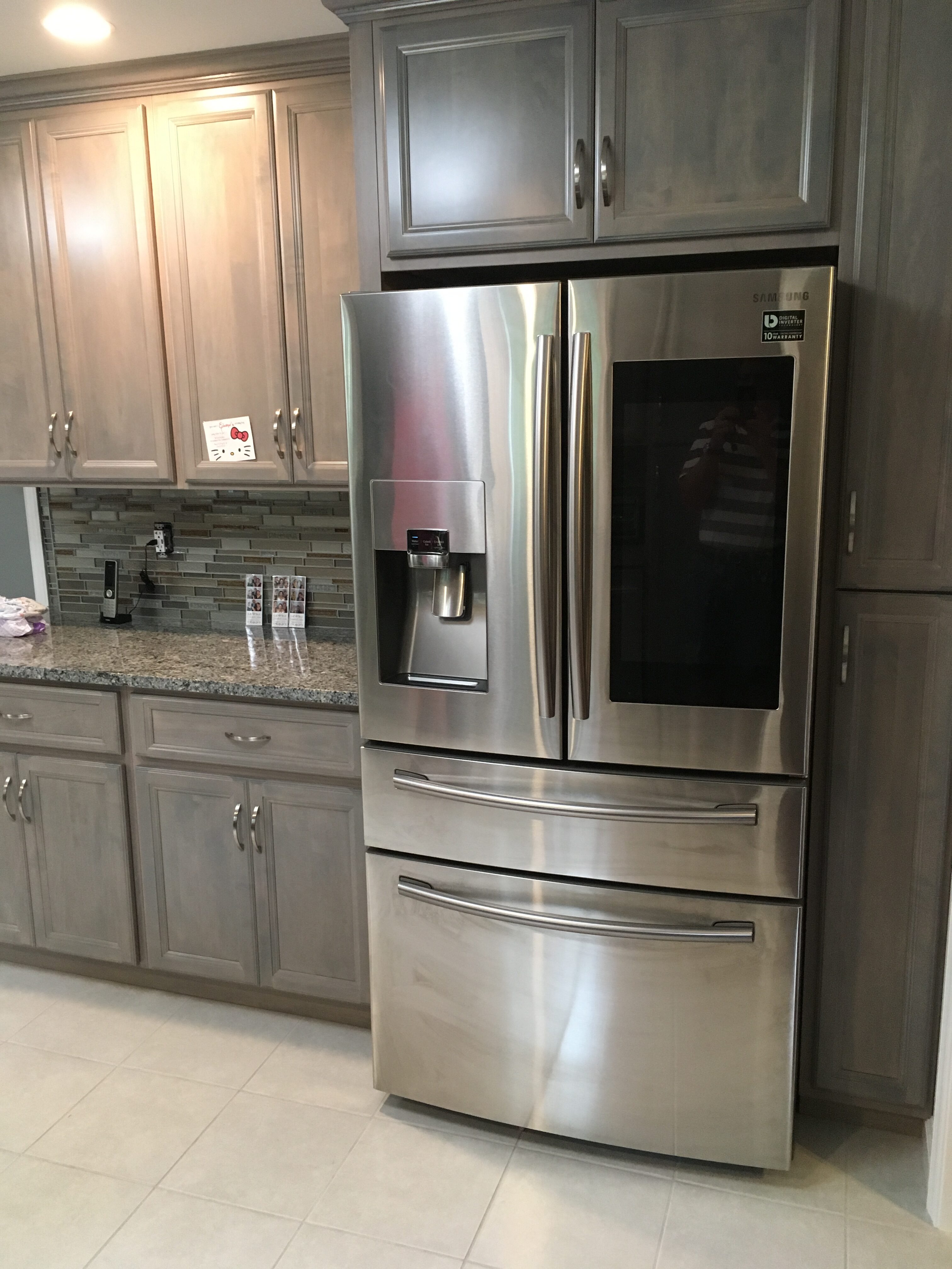 Gray stained cabinets with a gray and black granite counter top and stainless steel appliances in Bucks County, PA
