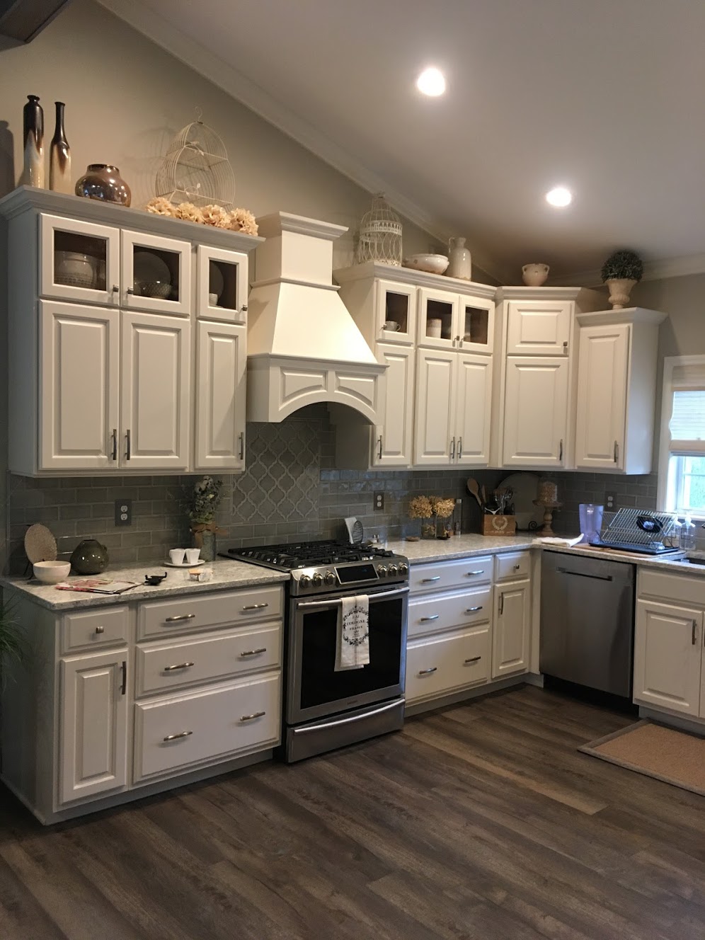 Beautiful White Kitchen, Decorative Tile Backsplash, Glass Front Door, Decorative Hood and Stainless Steel Appliances